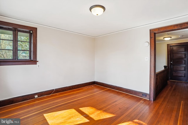 spare room with dark wood-type flooring and baseboards