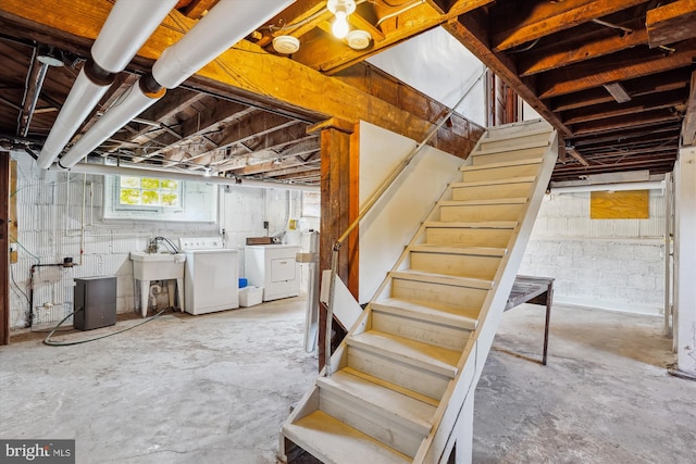 basement featuring washer and dryer, stairs, and a sink