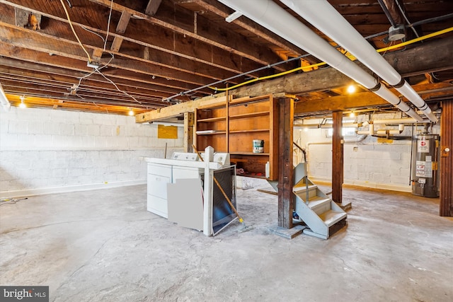 unfinished below grade area with stairway, gas water heater, and separate washer and dryer