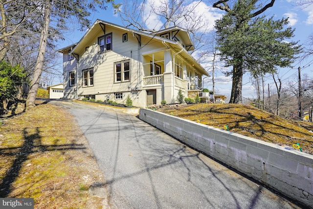 view of side of home featuring aphalt driveway and a garage