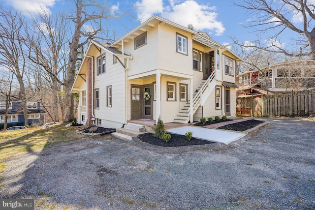 view of front facade with stucco siding and fence