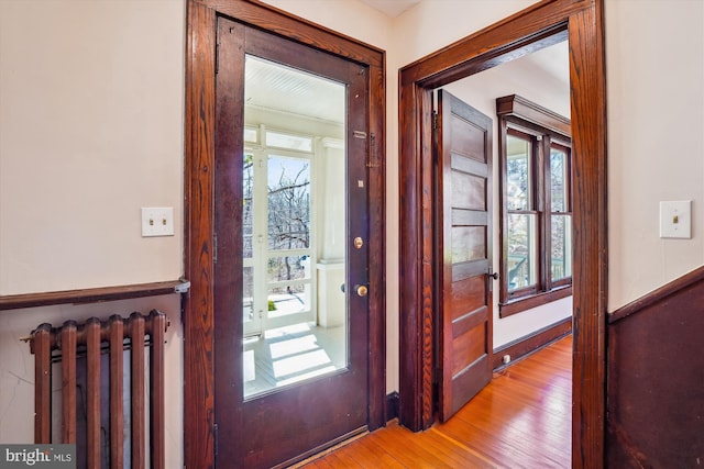 foyer with radiator and light wood finished floors