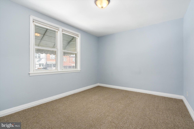 carpeted empty room with baseboards