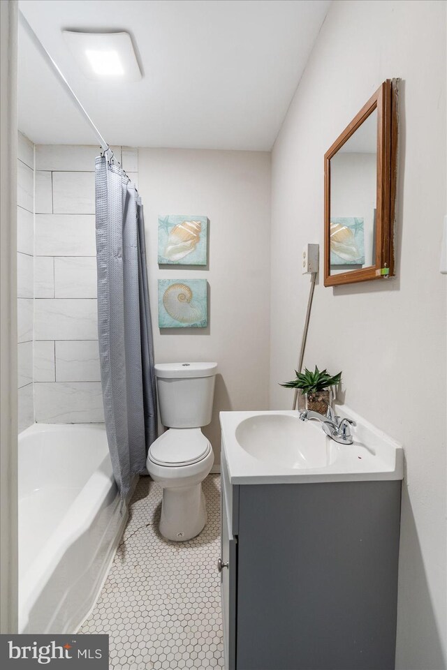 full bath with toilet, vanity, and shower / tub combo with curtain