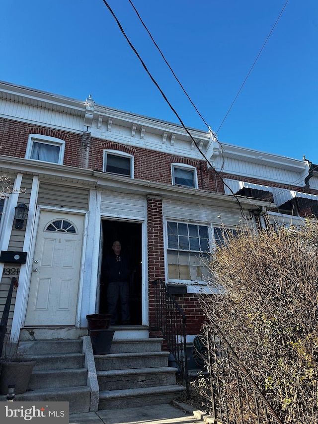 view of front of home with entry steps and brick siding