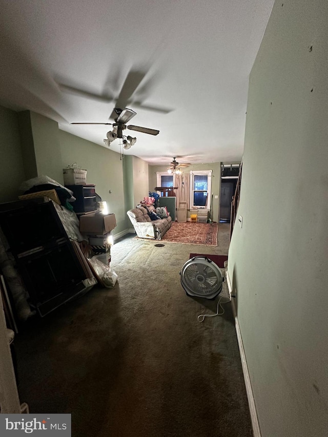 carpeted living area featuring baseboards and ceiling fan