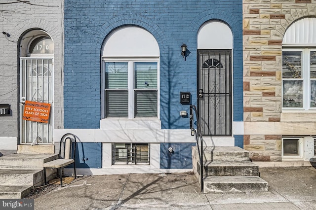 view of exterior entry featuring brick siding