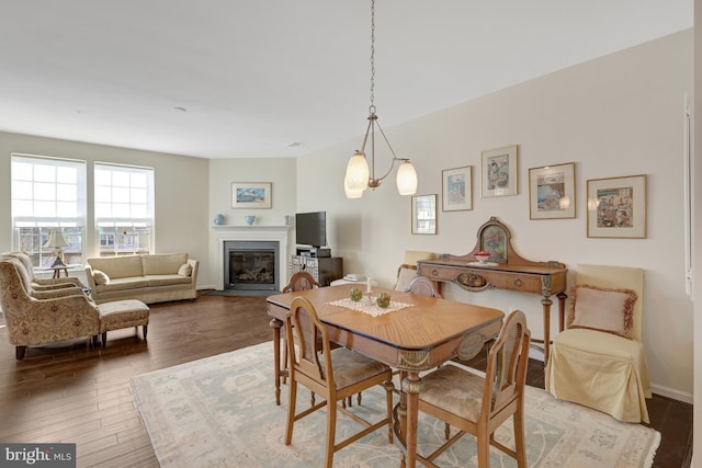 dining room with a glass covered fireplace and wood finished floors