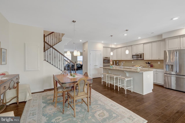 dining room featuring dark wood finished floors, stairway, and recessed lighting