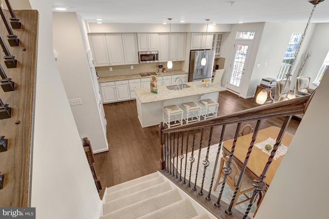 stairway with recessed lighting, baseboards, and wood finished floors