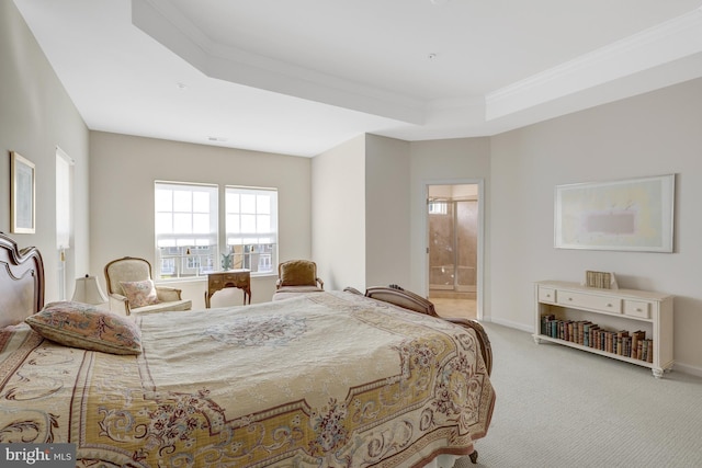 carpeted bedroom with connected bathroom, a raised ceiling, baseboards, and ornamental molding