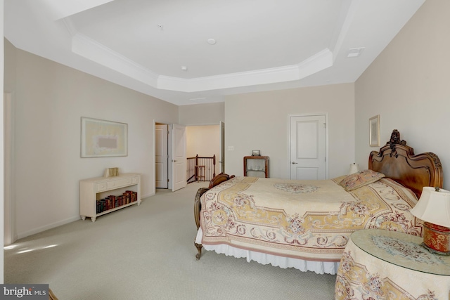 bedroom with a tray ceiling, carpet floors, and crown molding