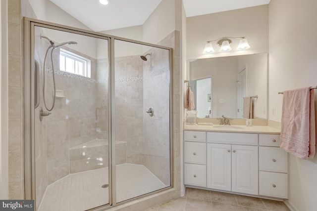 full bathroom featuring tile patterned floors, lofted ceiling, vanity, and a shower stall