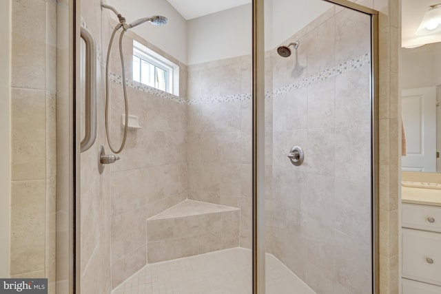 full bath with a stall shower and vanity