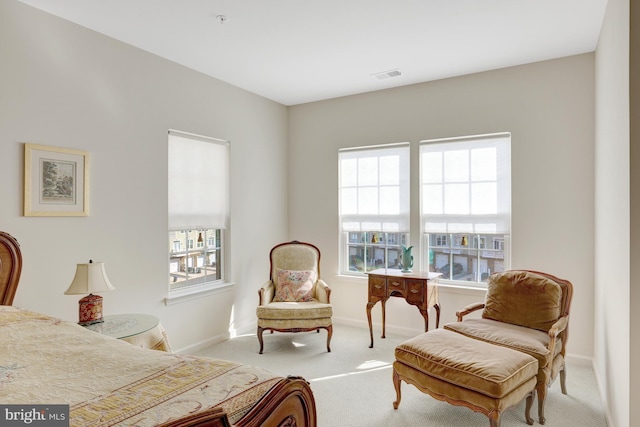 living area with baseboards, plenty of natural light, and carpet flooring