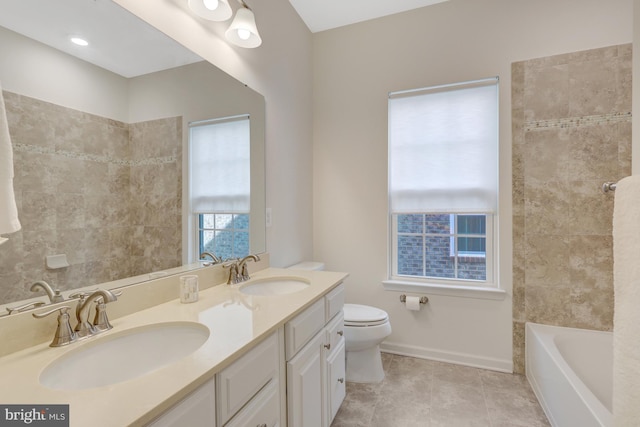 full bathroom with double vanity, toilet, a bathing tub, and a sink