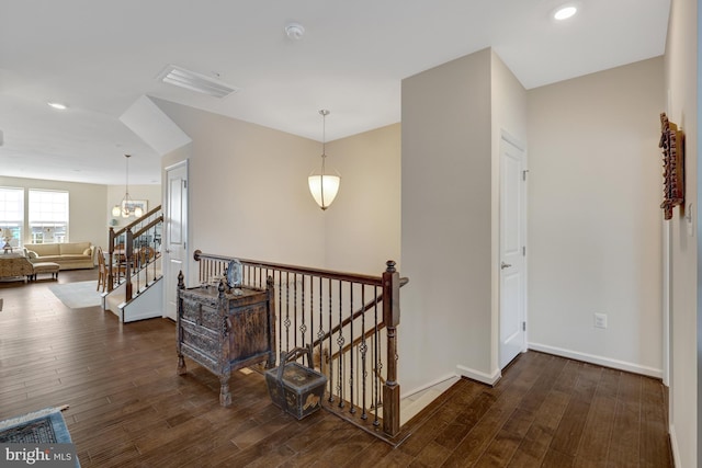 hall featuring dark wood-style floors, baseboards, recessed lighting, stairs, and an upstairs landing