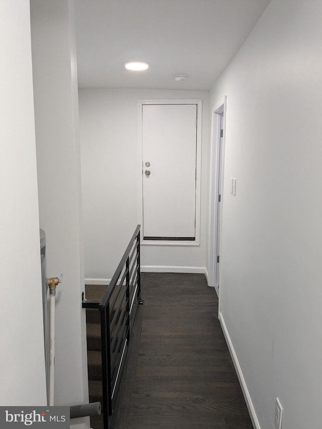 hall with dark wood-type flooring and baseboards