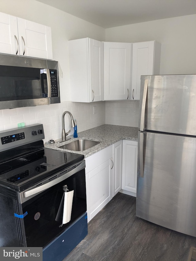 kitchen featuring a sink, light stone counters, white cabinetry, and stainless steel appliances