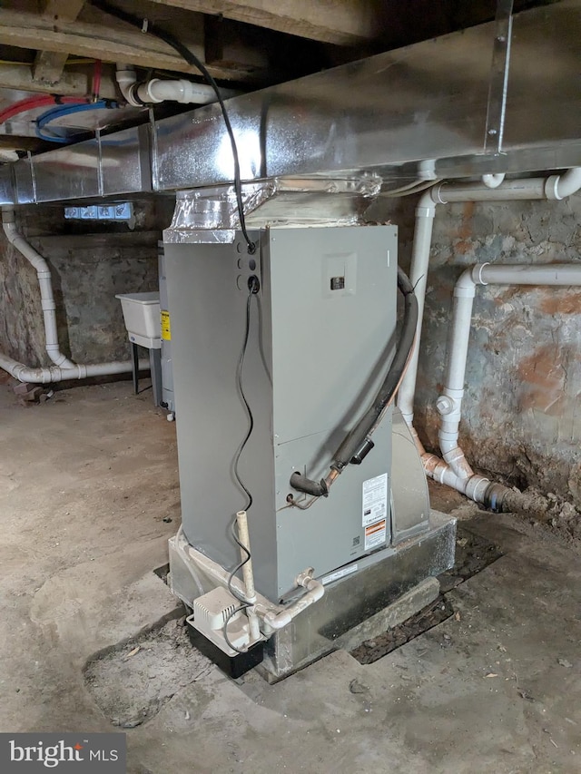 utility room featuring heating unit and a sink