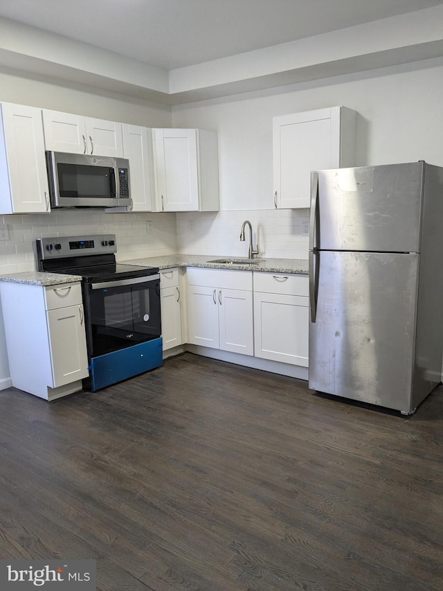 kitchen with a sink, white cabinets, dark wood-style floors, and stainless steel appliances