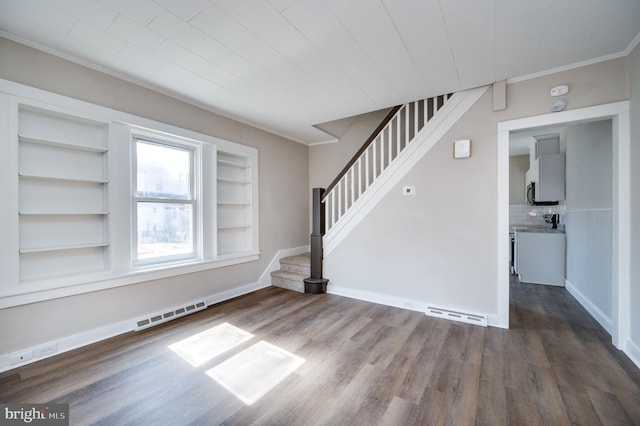 interior space with visible vents, dark wood-type flooring, crown molding, baseboards, and stairs