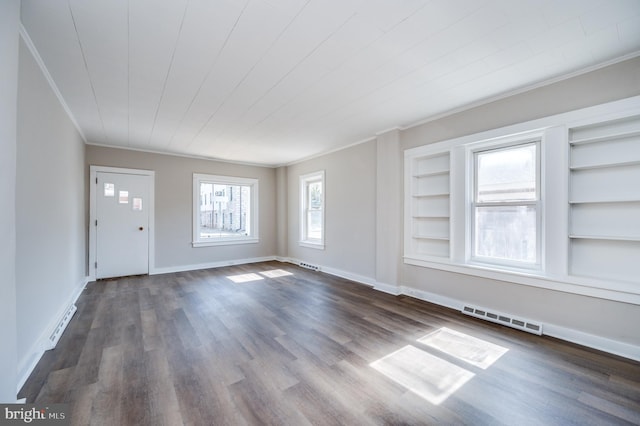 unfurnished living room with built in shelves, baseboards, visible vents, dark wood finished floors, and ornamental molding