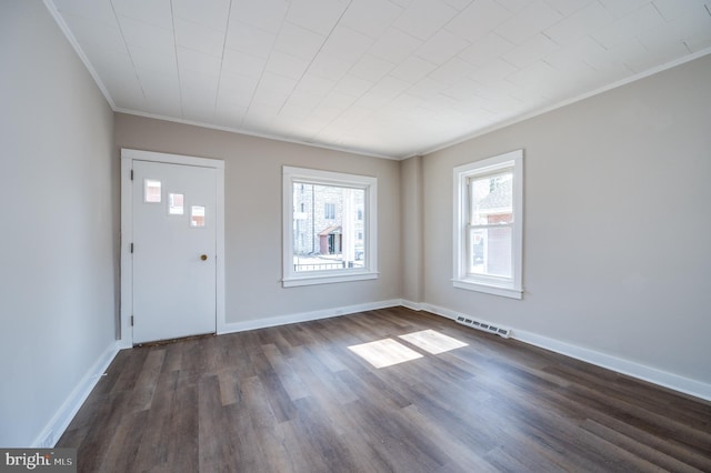 entryway with dark wood-type flooring, baseboards, visible vents, and ornamental molding