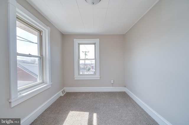 unfurnished room featuring visible vents, baseboards, and carpet