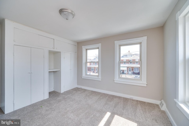 unfurnished bedroom featuring carpet, visible vents, and baseboards