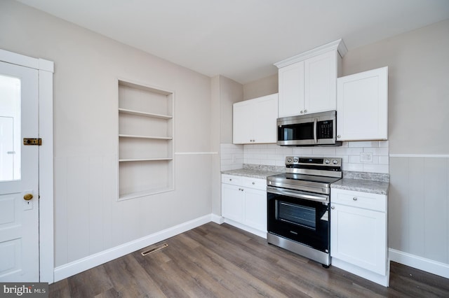 kitchen with built in features, visible vents, dark wood finished floors, stainless steel appliances, and white cabinetry