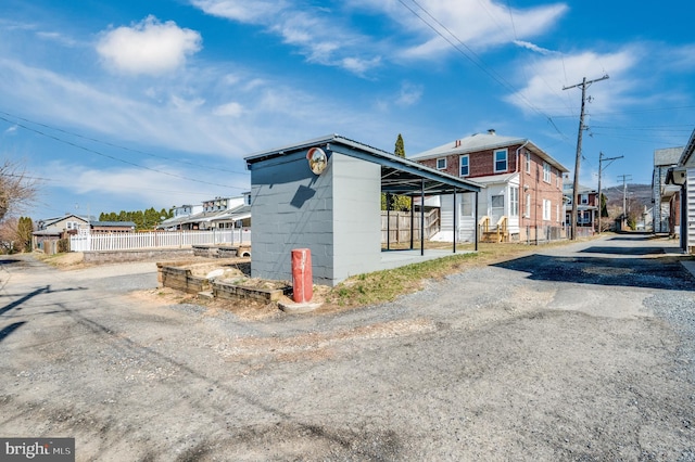 view of side of home featuring concrete block siding, fence, and a residential view