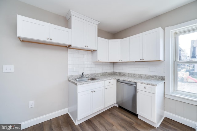 kitchen featuring a sink, tasteful backsplash, stainless steel dishwasher, white cabinetry, and light countertops