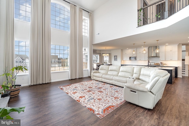 living room featuring dark wood finished floors, plenty of natural light, baseboards, and visible vents