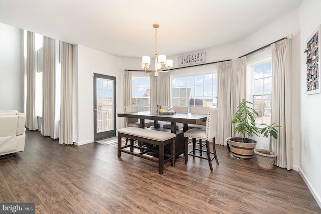 dining room with a wealth of natural light, a notable chandelier, baseboards, and dark wood-style flooring