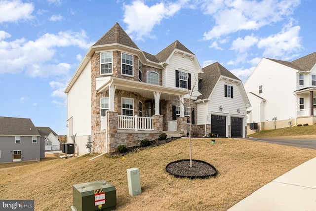 view of front of property with aphalt driveway, a porch, central AC, stone siding, and an attached garage