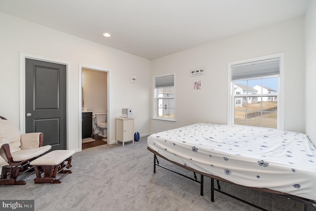 bedroom featuring recessed lighting, light colored carpet, baseboards, and connected bathroom