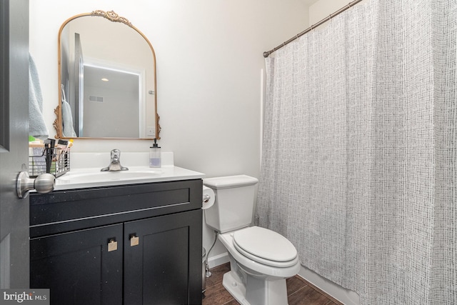 bathroom with vanity, a shower with shower curtain, toilet, and wood finished floors