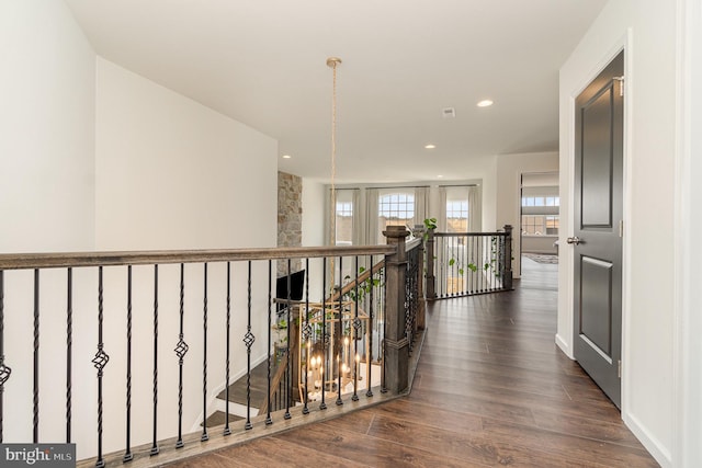 hallway with recessed lighting, an upstairs landing, and wood finished floors