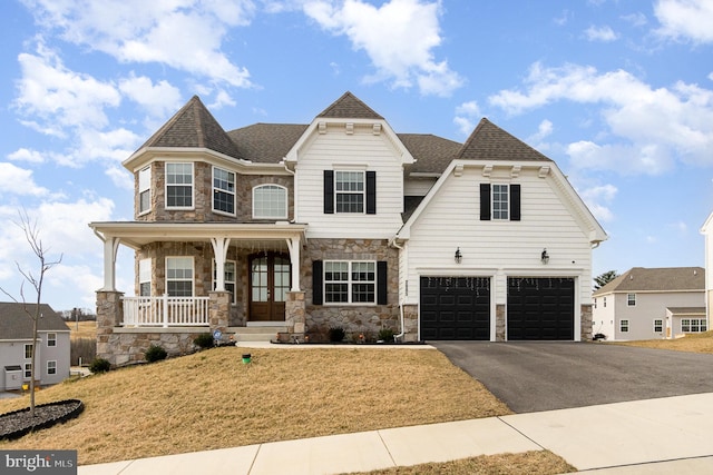 view of front of property featuring driveway, stone siding, a porch, an attached garage, and a shingled roof