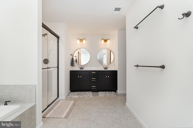 full bathroom featuring a shower stall, tile patterned floors, double vanity, a bath, and a sink