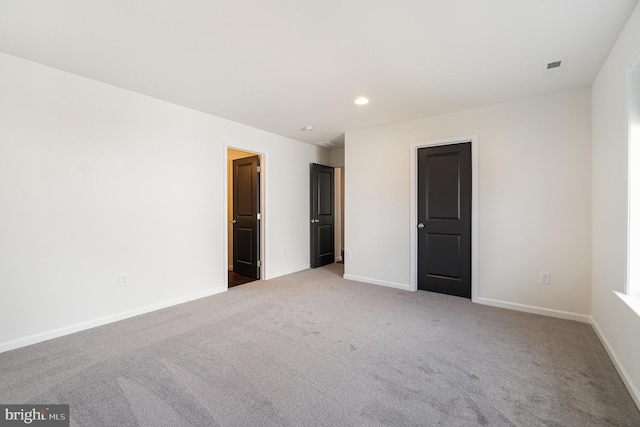 carpeted empty room featuring visible vents, recessed lighting, and baseboards