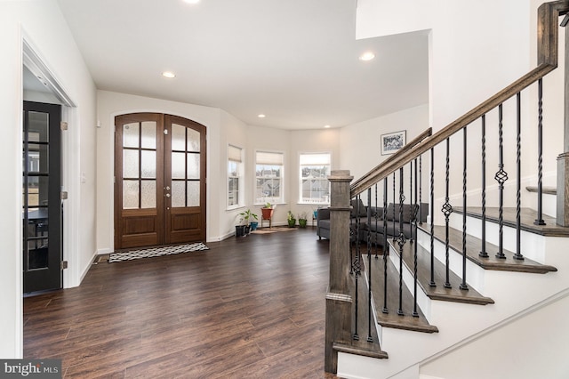 foyer with wood finished floors, recessed lighting, french doors, and arched walkways