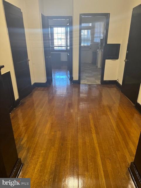 hall with baseboards and wood finished floors