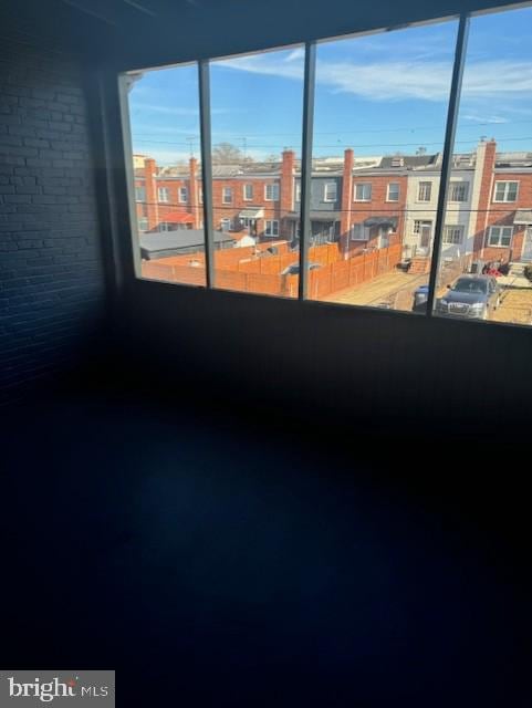 spare room featuring plenty of natural light and brick wall