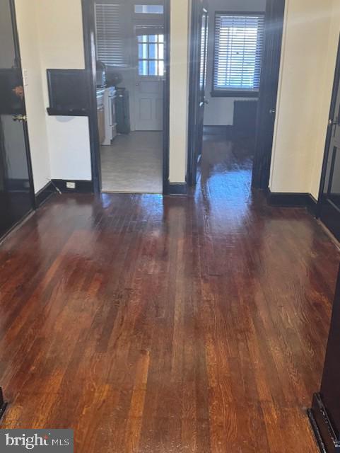 interior space with baseboards and dark wood-style floors