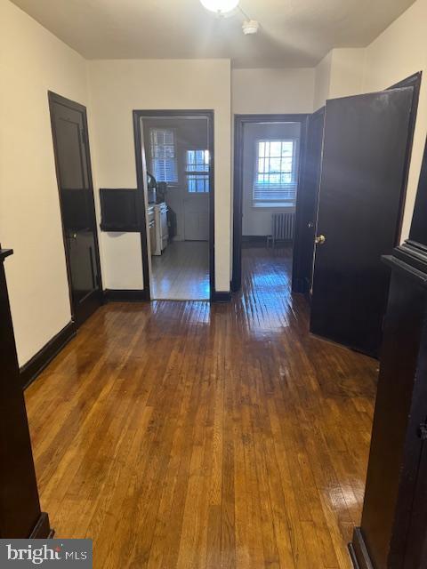 interior space featuring dark wood finished floors, radiator, and baseboards