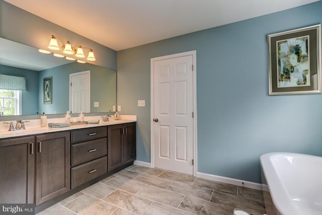 full bath featuring a sink, a freestanding tub, baseboards, and double vanity