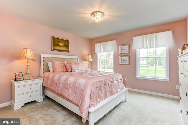 bedroom with baseboards and light colored carpet