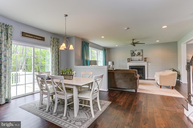 dining area featuring dark wood finished floors, a glass covered fireplace, recessed lighting, and a ceiling fan